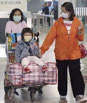 Passengers at Beijing airport wear masks for SARS